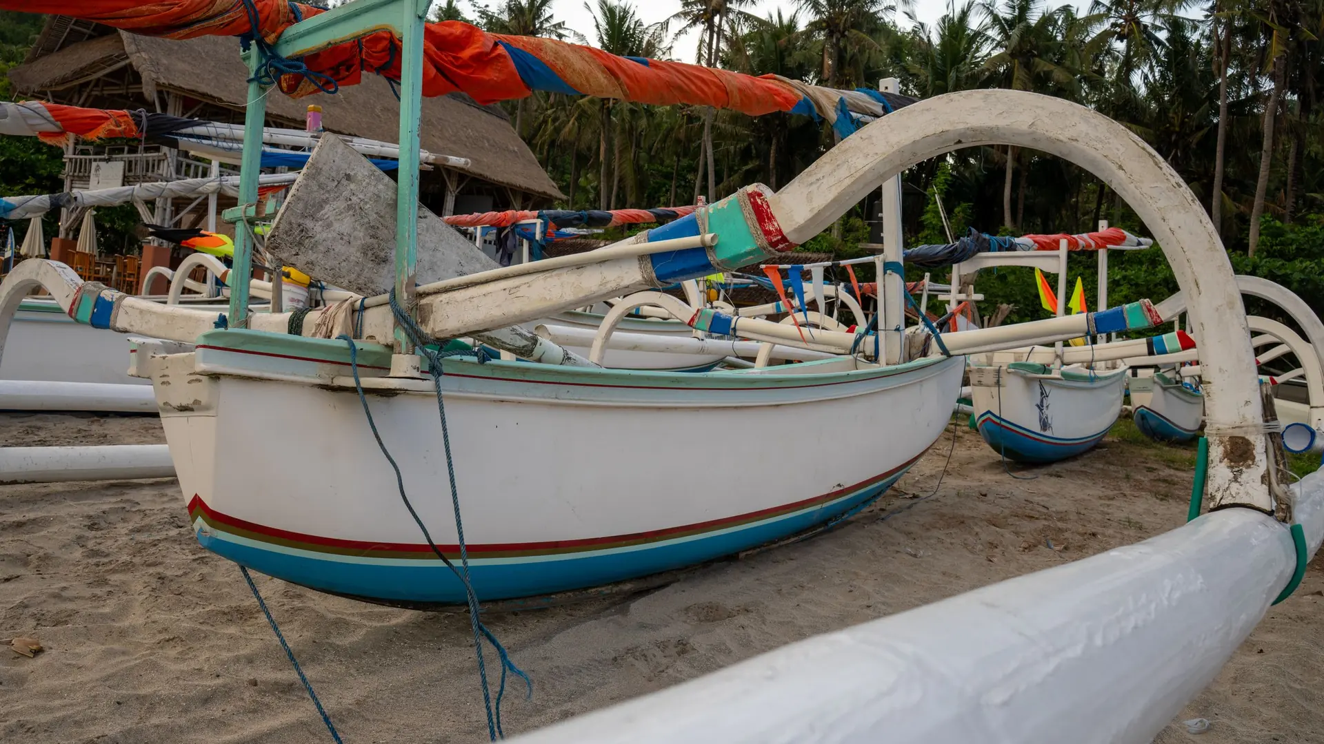Brightly painted jukung outrigger boats pulled up on a beach